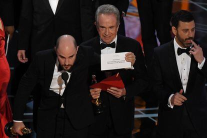 El actor Warren Beatty (centro) muestra el sobre correcto tras rectificar el error.