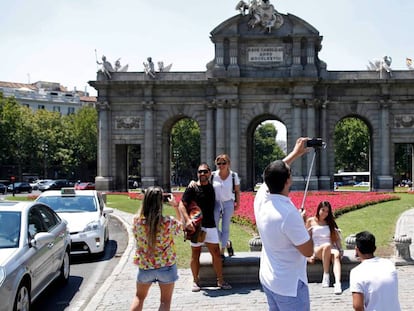 Turistas se fotografían en la madrileña Puerta de Alcalá. 