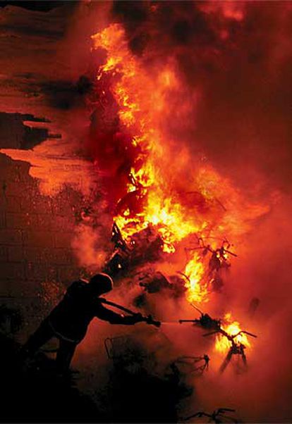 Los bomberos intentando sofocar el fuego que destruyó 21 motocicletas en el Casc Antic de Barcelona. 

/