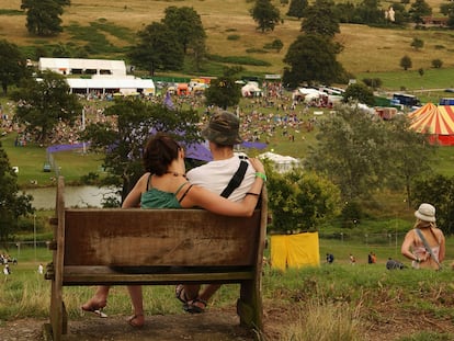 Dos jóvenes miran desde lejos algunas de las carpas en un festival de música al aire libre.