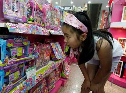 Una niña frente a un expositor de juguetes Mattel.