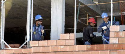 Tres obreros trabajan en la construcci&oacute;n de una vivienda de Bilbao.