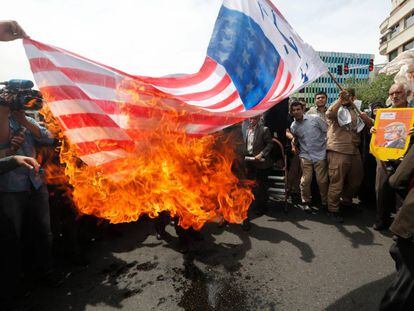 Manifestantes iraníes prenden fuego a una bandera improvisada de los EE. UU. durante una manifestación en Teherán. 
