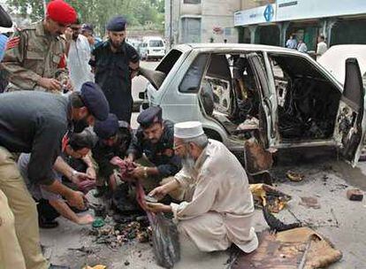 Policías paquistaníes examinan ayer el explosivo hallado en un coche en Peshawar que no llegó a estallar.