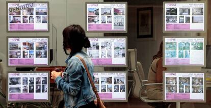 Una persona pasa ante el escaparate de una inmobilaria.