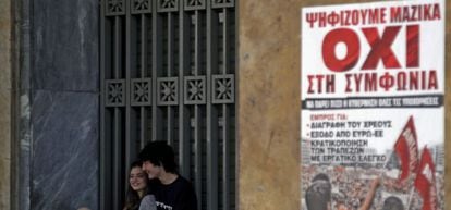 Una pareja junto a un cartel que pide el &quot;no&quot; en el refer&eacute;ndum del domingo, en Atenas