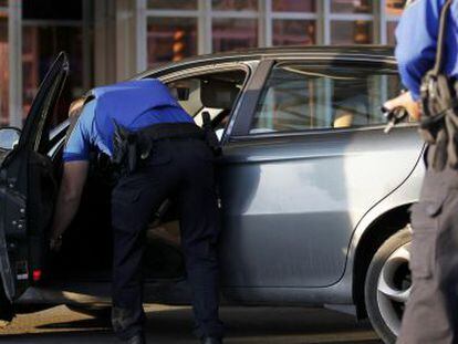 Oficiales de polic&iacute;a de Ginebra requisan un coche este viernes en el aeropuerto Cointrin tras elevar el nivel de alerta de ataques terroristas.