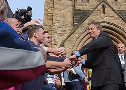 Blair saluda a sus seguidores a la salida de misa en Blackpool, donde se celebra el congreso semestral laborista.