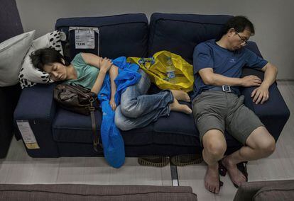 Una pareja disfruta de su descanso en uno de los sillones expuestos en la tienda de Pekín.