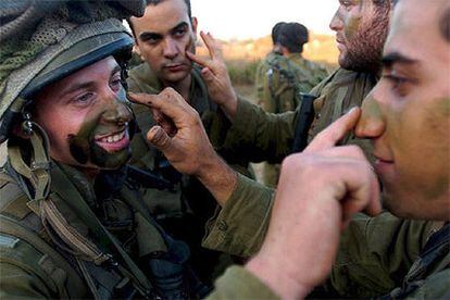 Soldados israelíes se pintan la cara antes de pasar a Líbano para una misión.