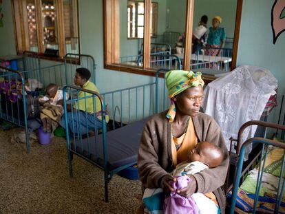 Una madre acuna en sus brazos a su hijo, enfermo de malaria, en el hospital de Ibanda, en Uganda.