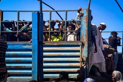 Unos niños se asoman entre los barrotes del camión que les transportará desde Joda a Renk, en Sudán del Sur, desde la frontera con Sudán. Los refugiados que se agolpan en la frontera deben esperar semanas para les saque de allí alguna organización humanitaria, pero estas están desbordadas.