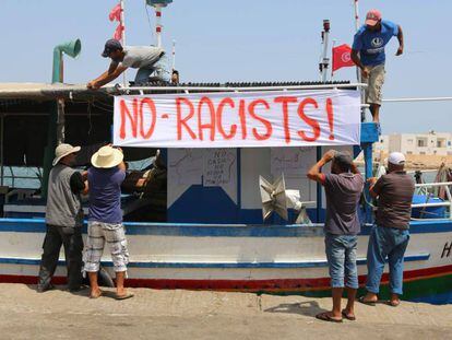 Pescadores tunecinos colocan una pancarta contra el nav&iacute;o anti-migrantes C-Star, este domingo en Zarzis.