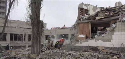 Varios trabajadores retiran los escombros de un colegio destruido por los bombardeos en Ucrania