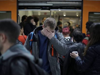 Pasajeros en la estación de Sants, ante un tren de Rodalies.