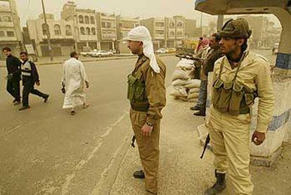 En medio de una gruesa tormenta de polvo, las milicias baazistas levantan parapetos de sacos terreros en Bagdad.