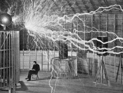 Nikola Tesla toma notas durante uno de sus experimentos.