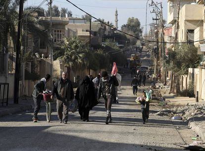 Un grupo de civiles sale a por comida en el este de Mosul el 17 de enero de 2017. 