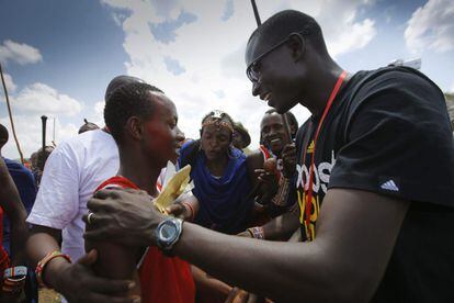Un masai (a la izquierda), que ganó la carrera de los 800 metros lisos es felicitado por el medallista de oro keniano David Rudisha (derecha) después de la prueba.