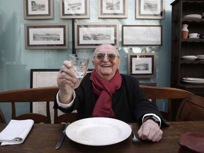 Juan Mari Arzak posa sentado en una de las mesas antiguas de su restaurante.