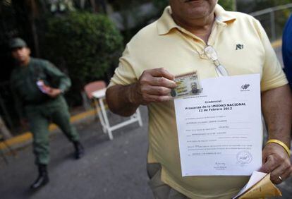 Un miembro de una mesa electoral del centro de Caracas muestra su credencial durante una jornada en la que los puestos electorales reciben y preparan el material suministrado por el Consejo Nacional Electoral (CNE).