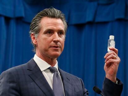 El gobernador de California, Gavin Newsom, muestra un bote de gel desinfectante en una conferencia de prensa, este miércoles en Sacramento.