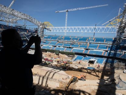 Un visitante del 'tour' del Santiago Bernabéu toma este jueves por la tarde una foto a las obras del estadio.