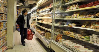 Una clienta frente a las estanterías de un supermercado