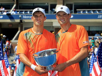 Mike Bryan y Bob Bryan posan con el trofeo de campeones del US Open.