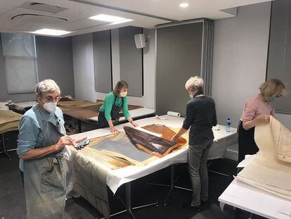Varios voluntarios ayudan en el proceso de restauración de mapas, ubicados en el sótano de la Jagger Library.