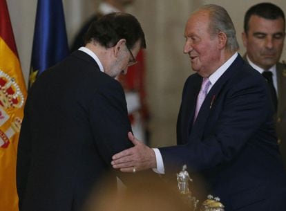 El Rey Juan Carlos saluda al presidente del Gobierno, Mariano Rajoy tras la firma de la ley orgánica que hará efectiva a medianoche su abdicación.