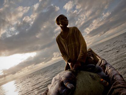 Se ve a Inocencio al amanecer en el lago Kivu en la piragua (canoa) en la que trabaja con su hermano Rigobert. Han recogido sus redes y contado su captura, preparándose para regresar a vender el pescado en el mercado.