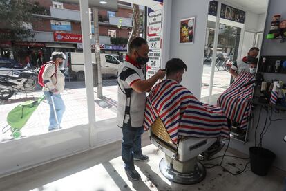 Mehdi Bendouh cortando el pelo en la peluquería de la calle de Alcalá que abrió a principios de septiembre.
