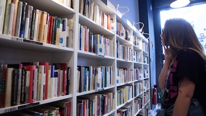 Una mujer revisa una estantería en una librería en Madrid.