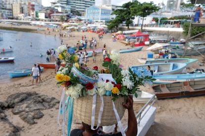 Un ciudadano en Salvador (Brasil) lleva flores como tributo a la playa de Río Vermelho, el 1 de febrero.