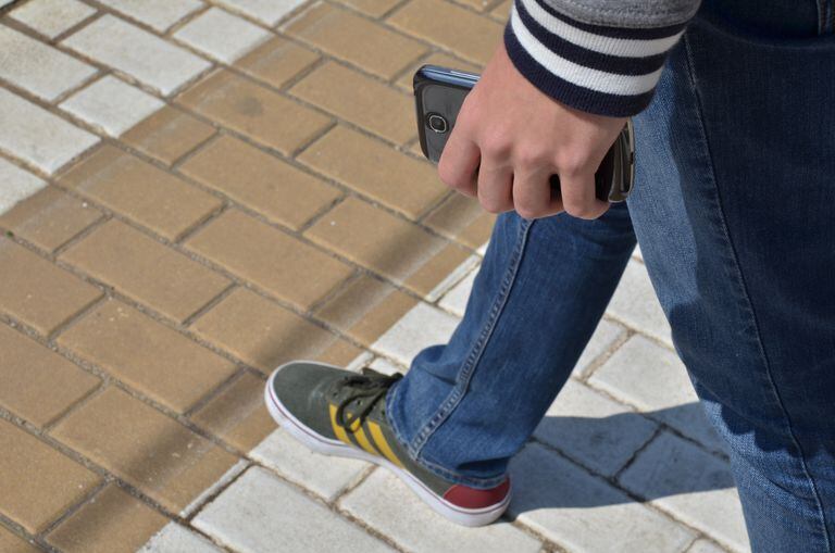 Persona andando con un móvil en la mano UPV 23/04/2020 