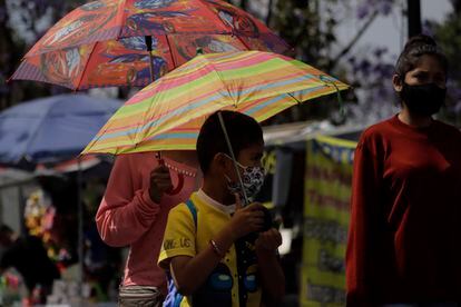 Transeúntes se cubren con sombrillas para mitigar el calor en la Ciudad de México, en marzo de 2022.