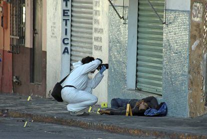 Una perito fotografía la escena de un crimen en Cuernavaca, Morelos.