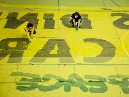 Unos vecinos de Manzanares el Real, confeccionan batas con una pancarta donada por Greenpeace.