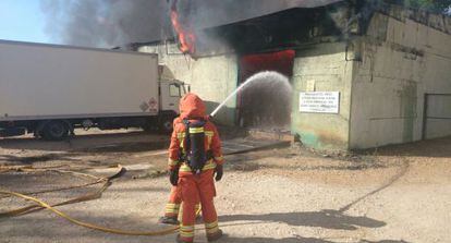 Dos bomberos durante la extinci&oacute;n del incendio en el almac&eacute;n de la pirotecnia de Tur&iacute;s.