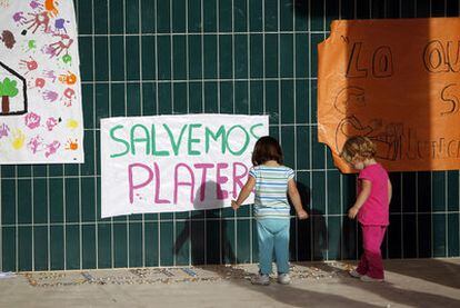 Unos niños junto a las pancartas para salvar el centro infantil de Meco.