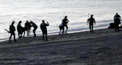 Los guardias civiles devuelven a inmigrantes a Marruecos en la playa deTarajal.