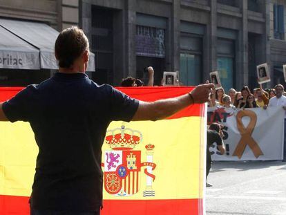 Un hombre con una bandera de España se encara con los centenares de personas que cortan la céntrica Via Laietana de Barcelona.