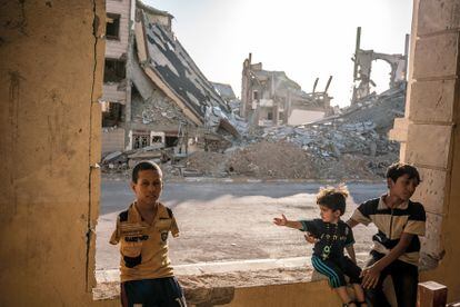     ----PIEFOTO----    Tres niños entre los edificios destruidos por la guerra. 