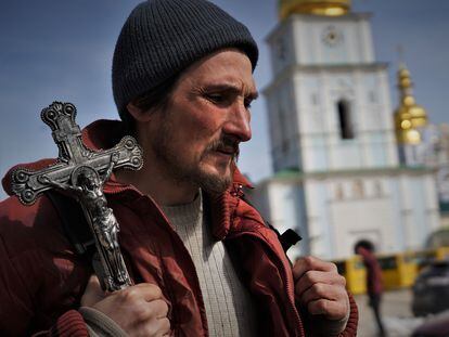 Un hombre se pasea con un crucifijo por los alrededores del monasterio de San Miguel de Kiev.