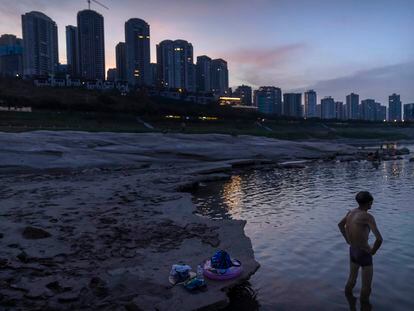 Un bañista junto al cauce parcialmente seco del río Yangtsé a su paso por la ciudad de Chongching, en el centro de China, en una imagen del pasado mes de agosto. El río se vio afectado por la sequía que asoló el país este verano.