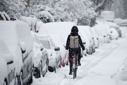 Una mujer se abre el paso con su bicicleta tras una nevada intensa en Munich (Alemania), la mañana del 10 de enero de 2019.