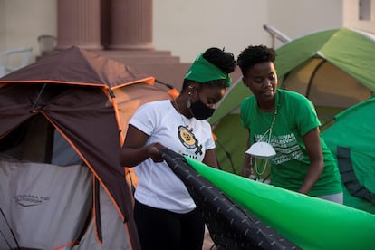 Jóvenes activistas levantan una carpa en el campamento que grupos feministas han montado frente al Palacio Nacional en Santo Domingo.