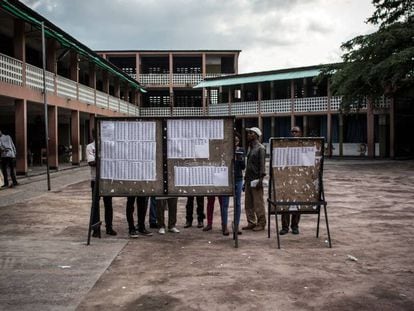 Un grupo de personas revisan las listas del censo en un colegio electoral de Kinshasa.