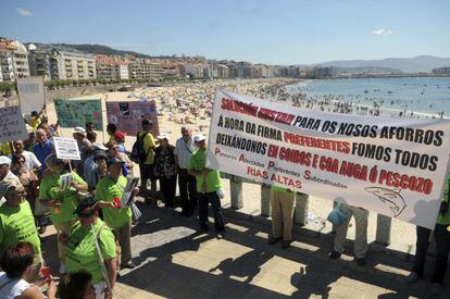 Los manifestantes afectados por las participaciones preferentes, ayer en la playa de Silgar de Sanxenxo.